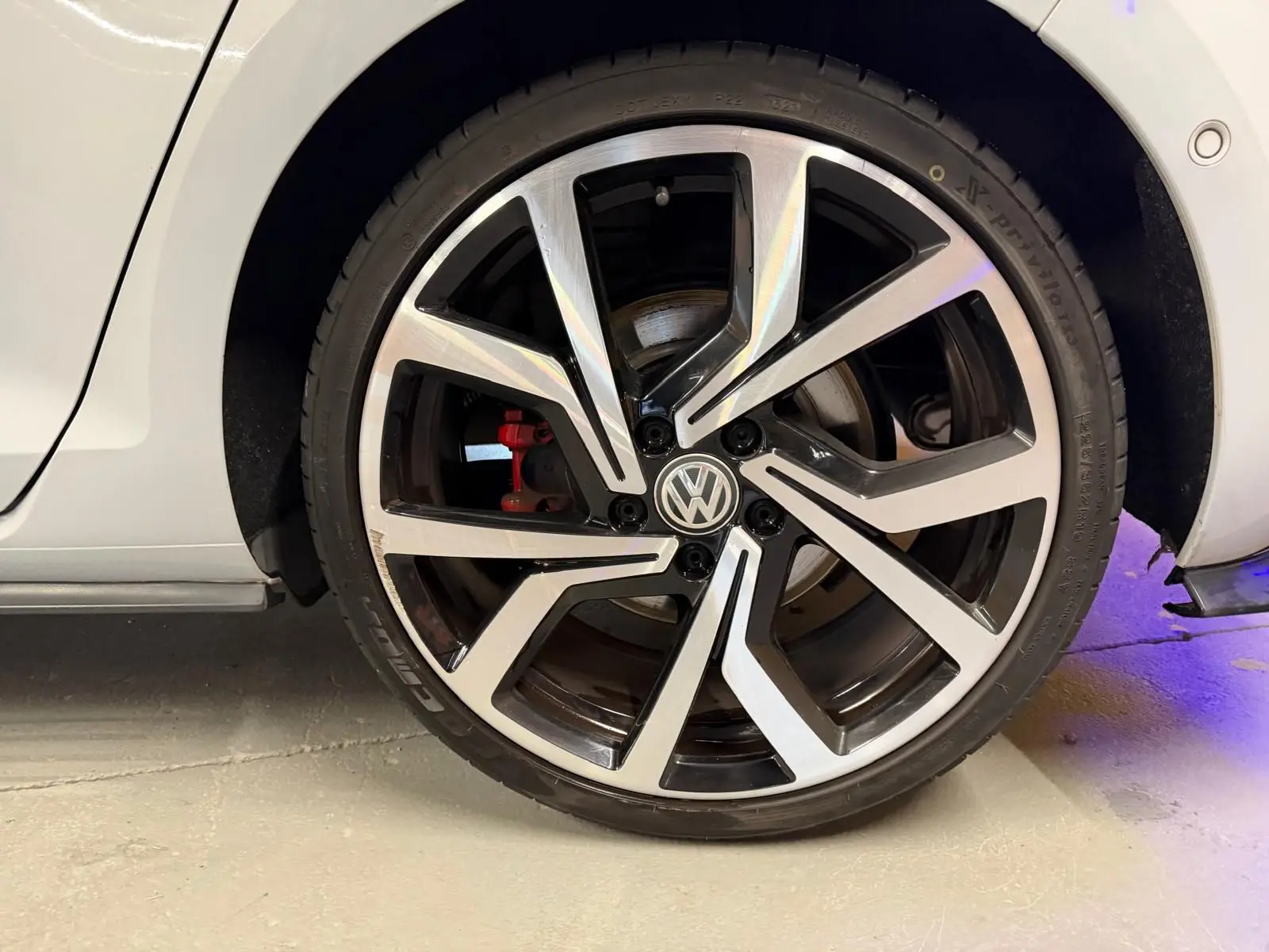 Gros plan sur la partie basse intérieure côté conducteur d'une Volkswagen Golf GTI Performance gris, avec seuil de porte en métal.