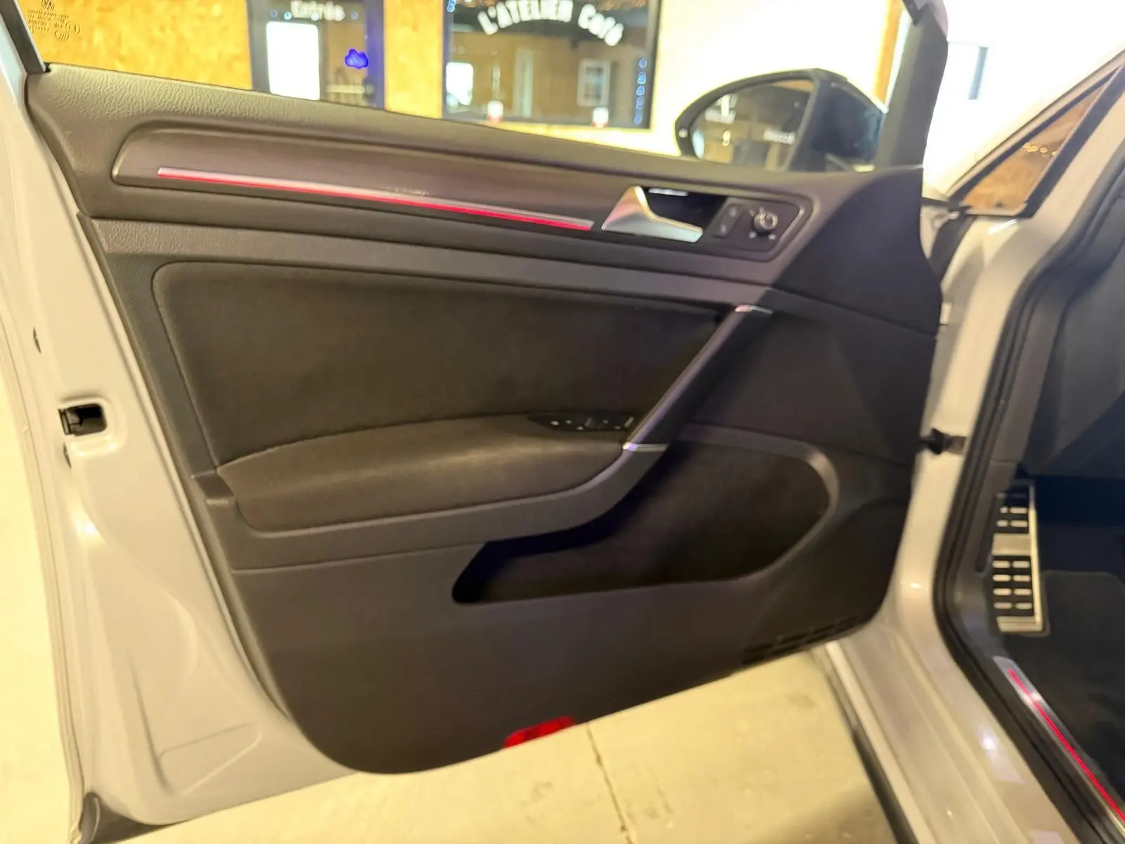 Gros plan sur le bouton de commande des phares dans l'habitacle d'une Volkswagen Golf GTI Performance gris.