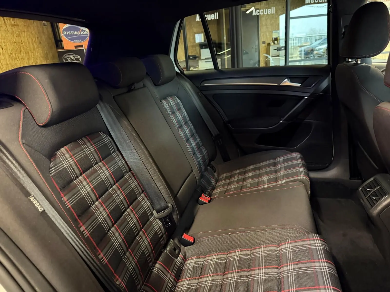 Vue arrière droite d'une Volkswagen Golf GTI Performance gris avec feux arrière LED allumés et logo GTI visible.