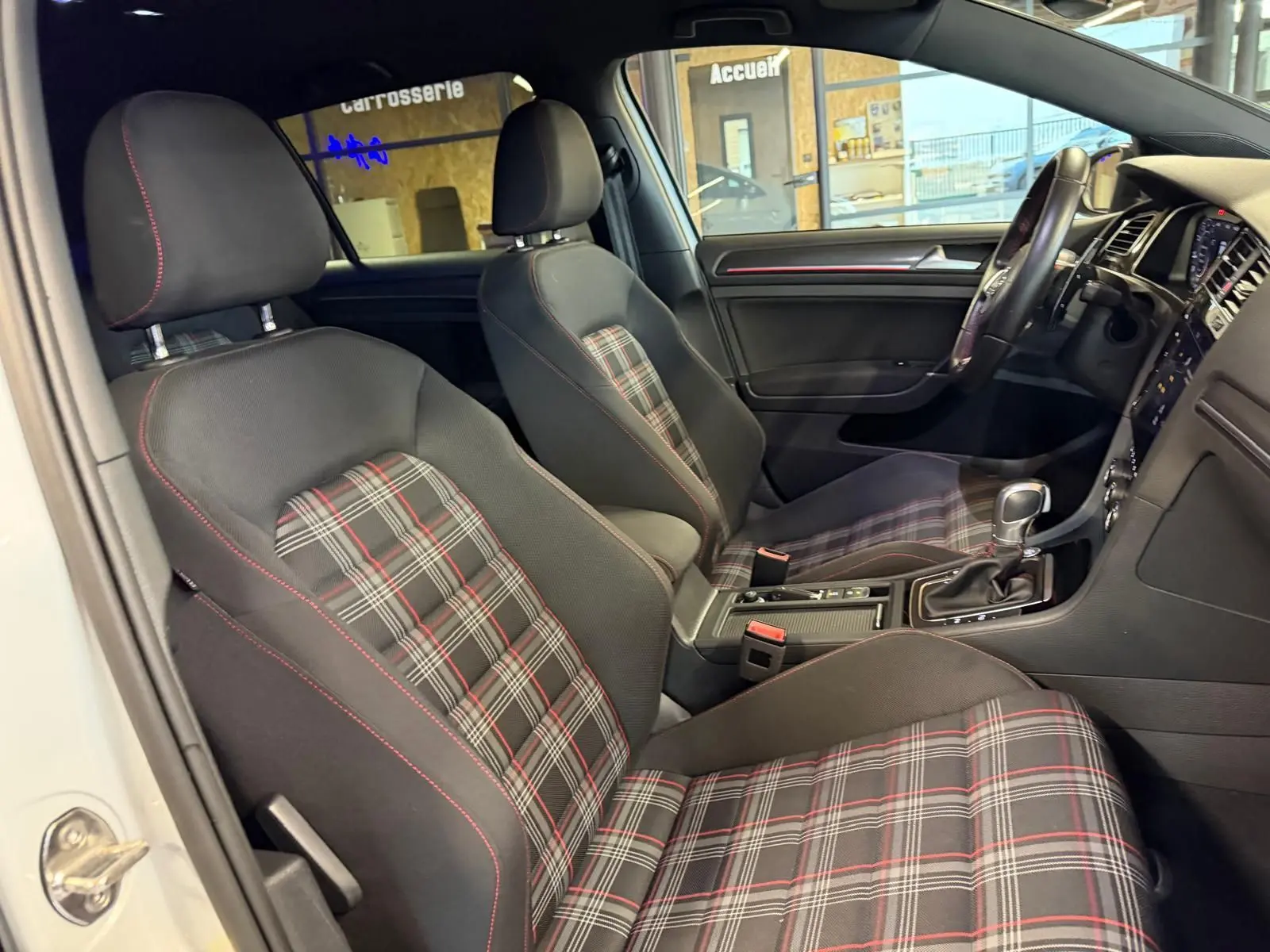 Gros plan sur l'arrière droit gris d'une Volkswagen Golf GTI Performance, avec sortie d'échappement chromée visible.