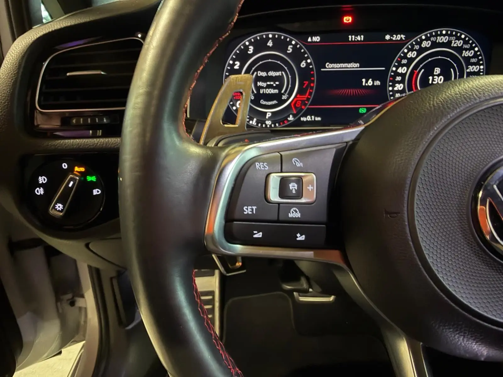 Vue intérieure de la porte arrière gauche ouverte d’une Volkswagen Golf GTI Performance grise, avec garniture noire et poignée argentée.