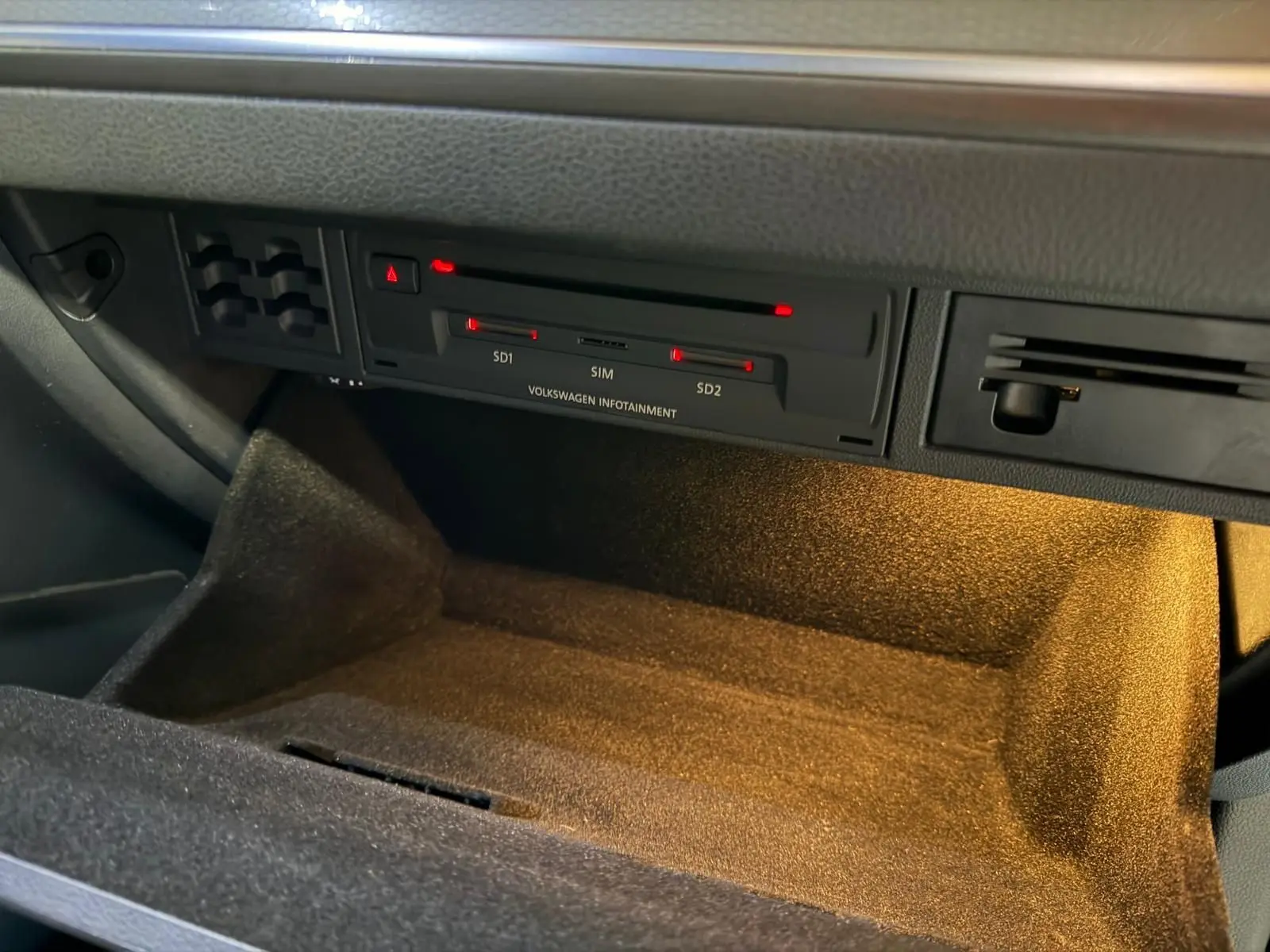 Gros plan avant gauche d'une Volkswagen Golf GTI Performance gris clair avec phares LED allumés et logo GTI rouge.