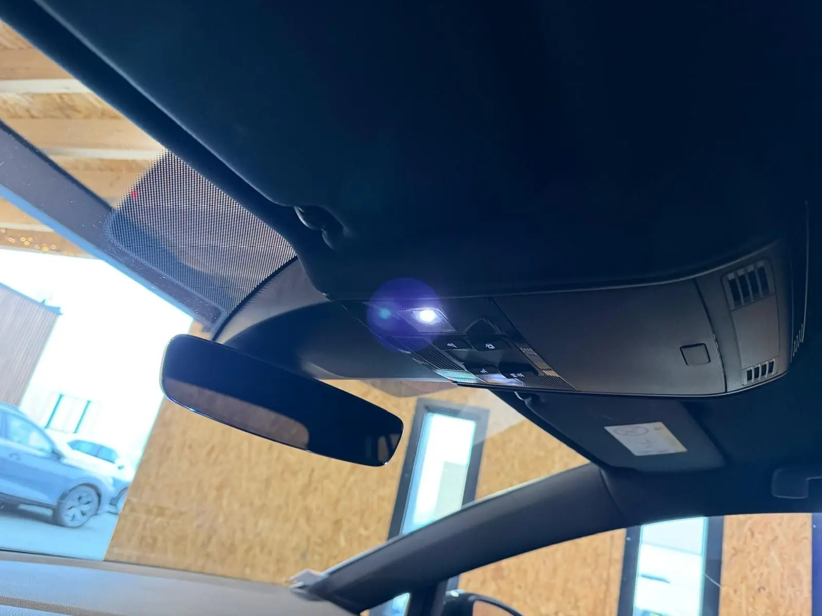 Gros plan sur l'emblème GTI rouge sur la portière côté gauche d'une Volkswagen Golf gris clair.