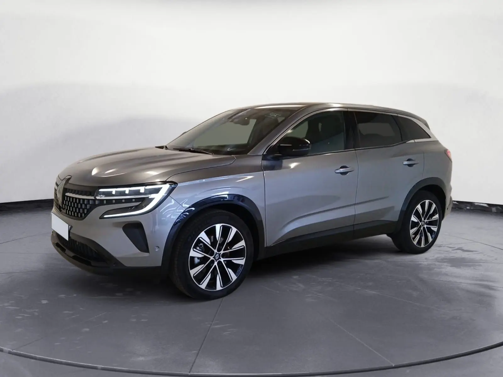 Renault Austral E-Tech 2024 gris métallisé en vue 3/4 avant droit avec jantes alliage noires et phares LED.
