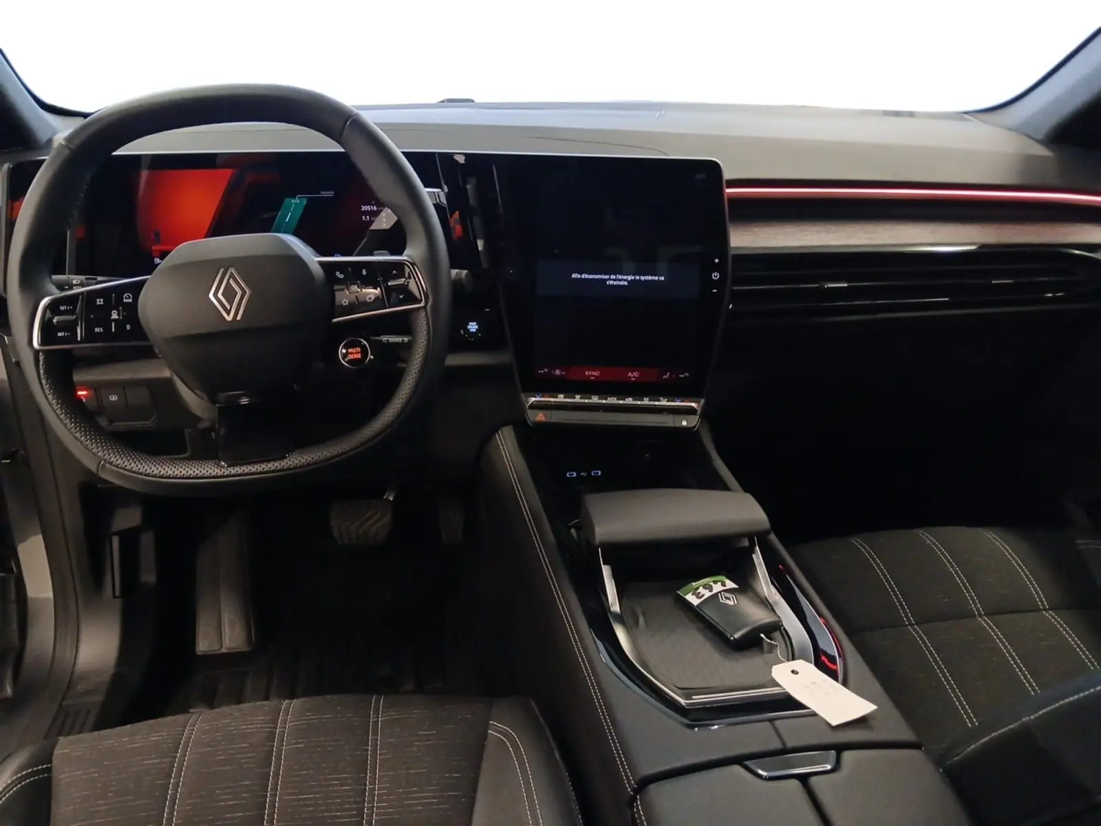 Vue intérieure avant du Renault Austral 2024, tableau de bord noir avec écran tactile vertical et volant multifonction.
