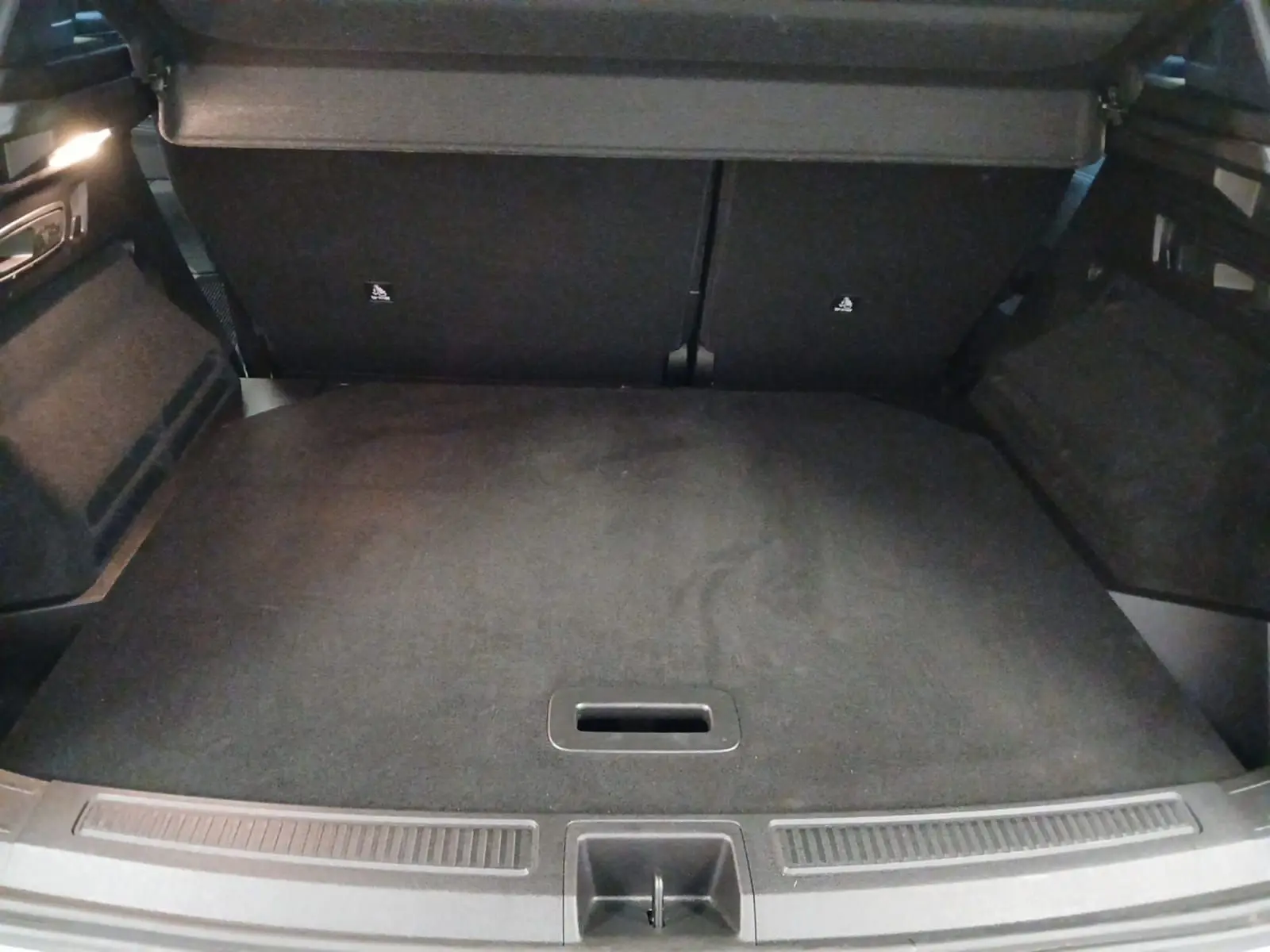 Vue du coffre arrière ouvert du Renault Austral 2024, avec plancher plat et revêtement noir uniforme.