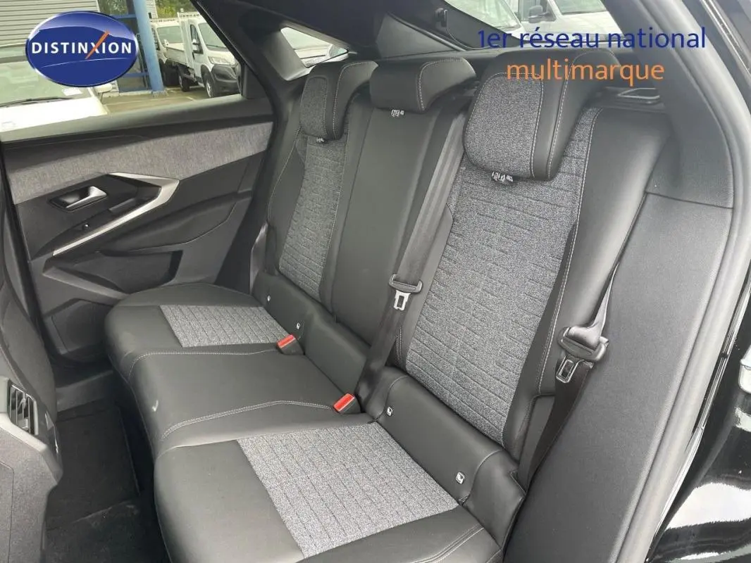 Vue intérieure côté gauche montrant la banquette arrière en cuir noir et tissu gris du Peugeot 3008 noir 2025.
