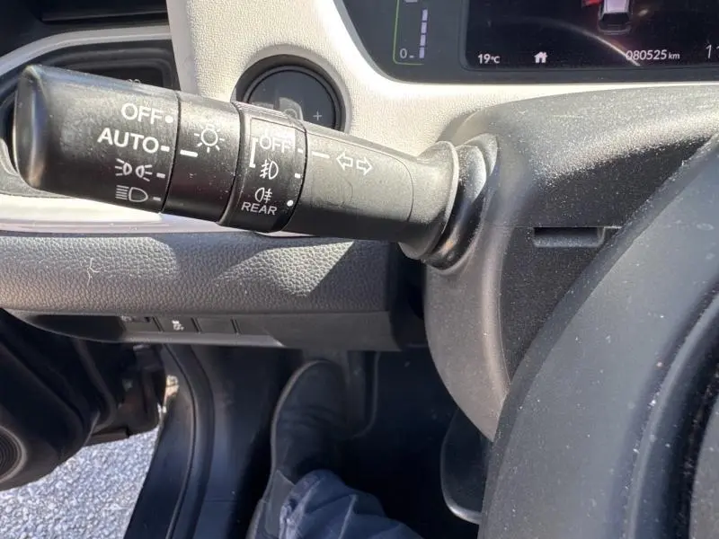 Gros plan sur le commodo d'éclairage à gauche du volant dans l'habitacle d'une Honda Jazz bleu nuit nacré 2021.