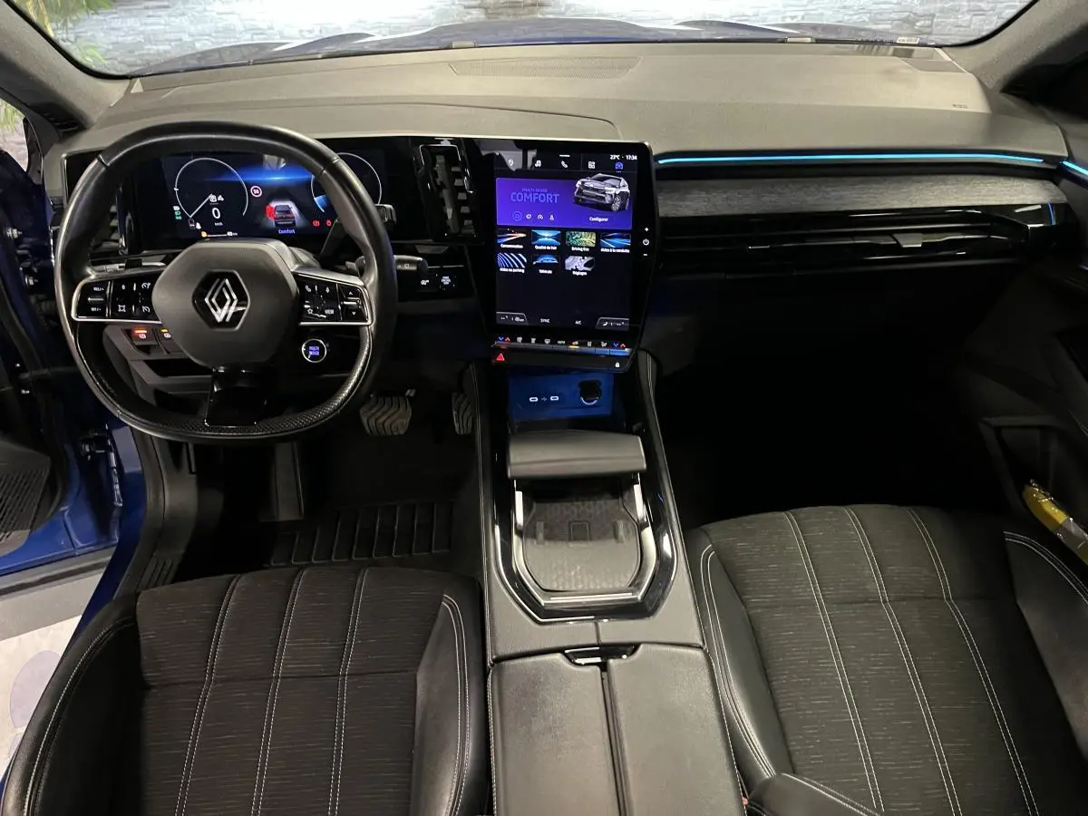 Intérieur avant du Renault Austral bleu, tableau de bord moderne avec écran tactile central et volant multifonction.
