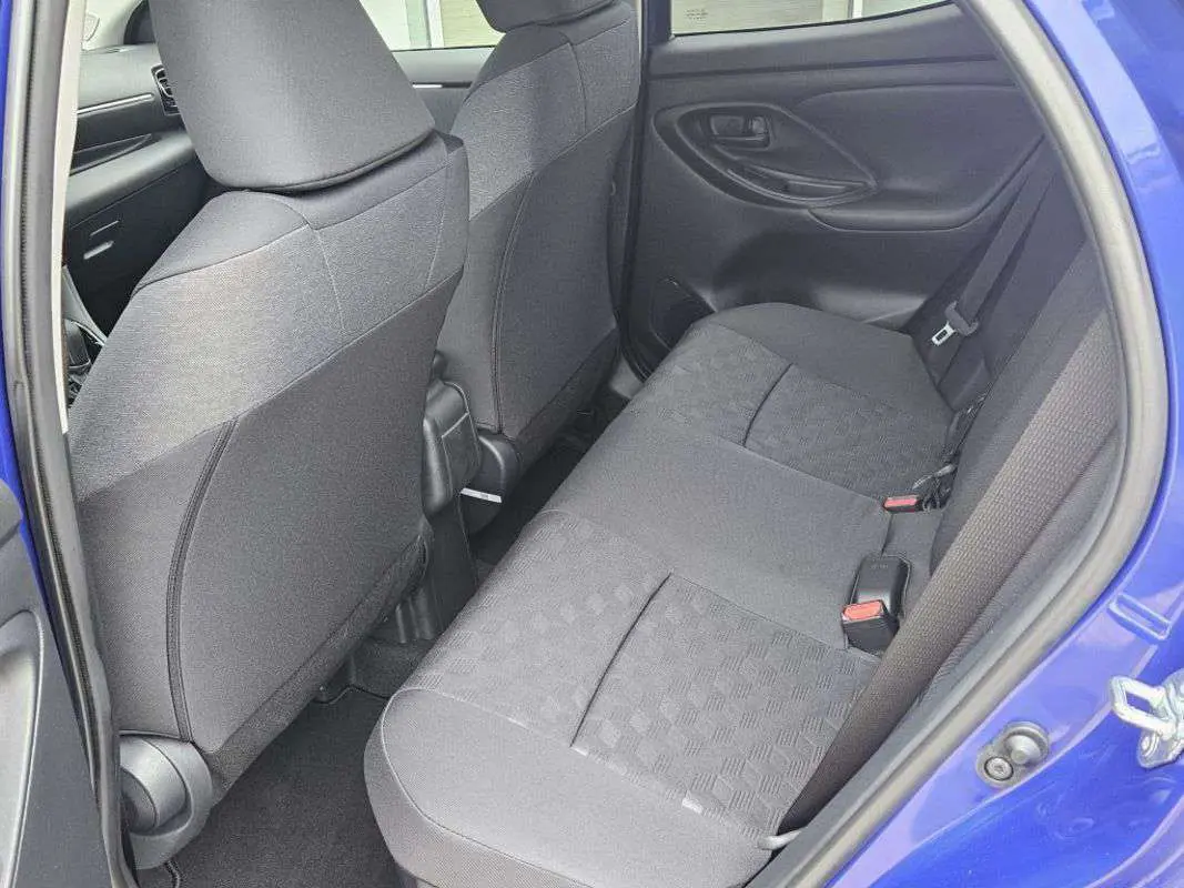 Vue intérieure arrière côté droit de la Toyota Yaris 2025 bleu genièvre, montrant les sièges arrière en tissu gris.