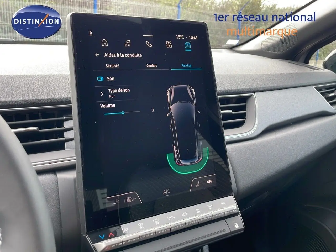 Vue intérieure du tableau de bord du Renault Captur E-Tech Hybrid 2025, écran tactile affichant l'aide au stationnement.