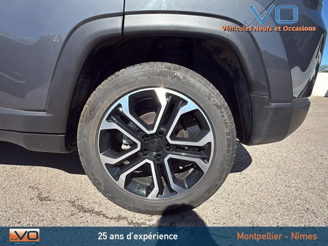 Gros plan sur la roue avant droite du Jeep Compass gris 2023 avec jante alliage 18 pouces au design moderne.