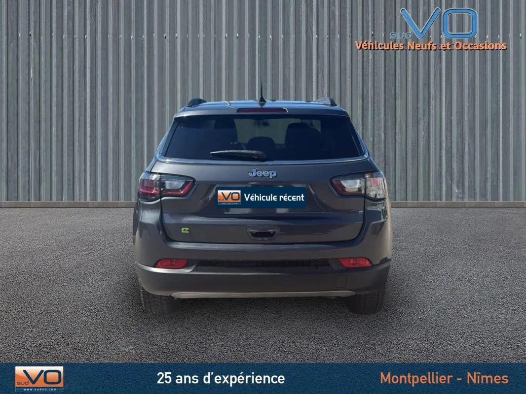Vue arrière d'un Jeep Compass gris 2023 avec barres de toit et feux arrière LED visibles.