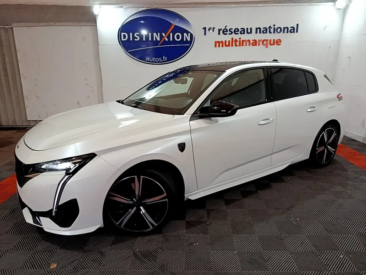 PEUGEOT 308 PHEV 180 GT blanc en 3/4 avant droit, avec phares LED et jantes noires distinctives.