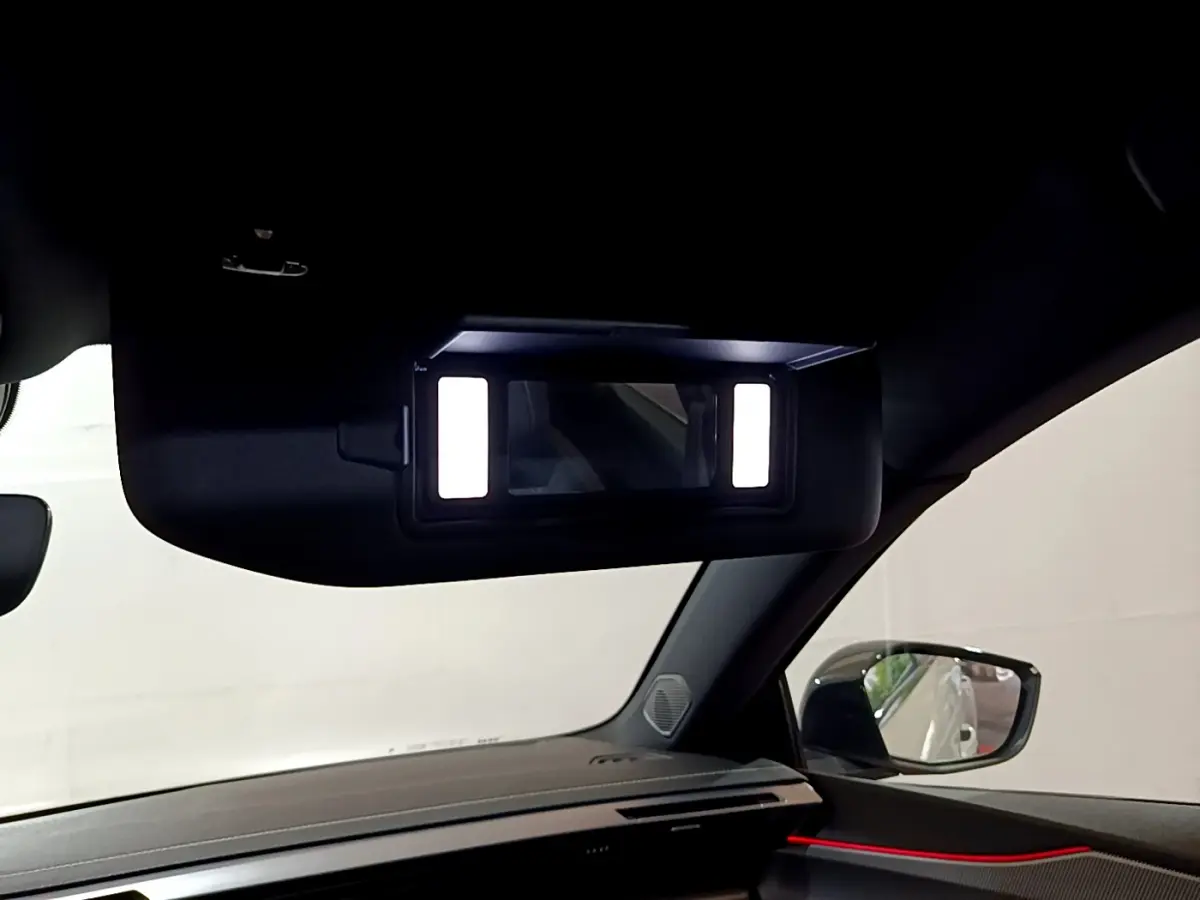 Détail intérieur du miroir de courtoisie éclairé côté passager dans la Peugeot 308 PHEV 180 E-EAT8 GT blanche 2022.