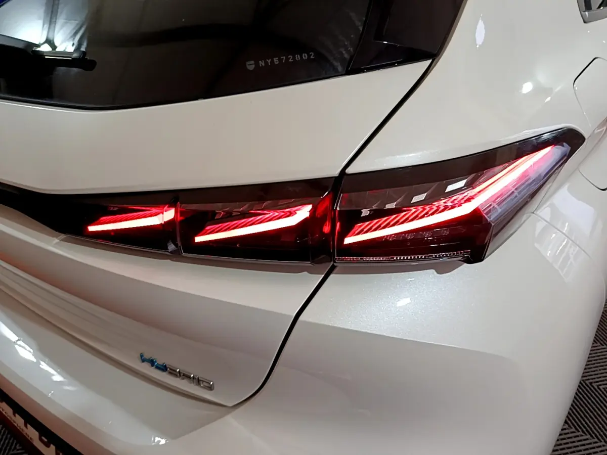 Gros plan sur le feu arrière droit allumé d'une Peugeot 308 PHEV 180 E-EAT8 GT blanche de 2022.