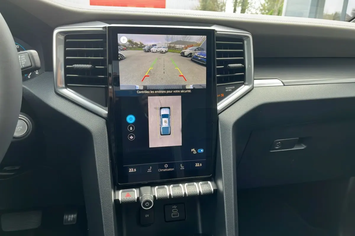 Vue rapprochée de la console centrale du Volkswagen Amarok noir 2025, écran tactile avec caméra 360° et commandes climatisation.