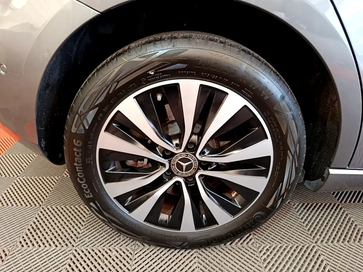 Gros plan sur la roue avant droite d'une Mercedes Classe A 250 e Business Line grise, jante alliage bicolore.