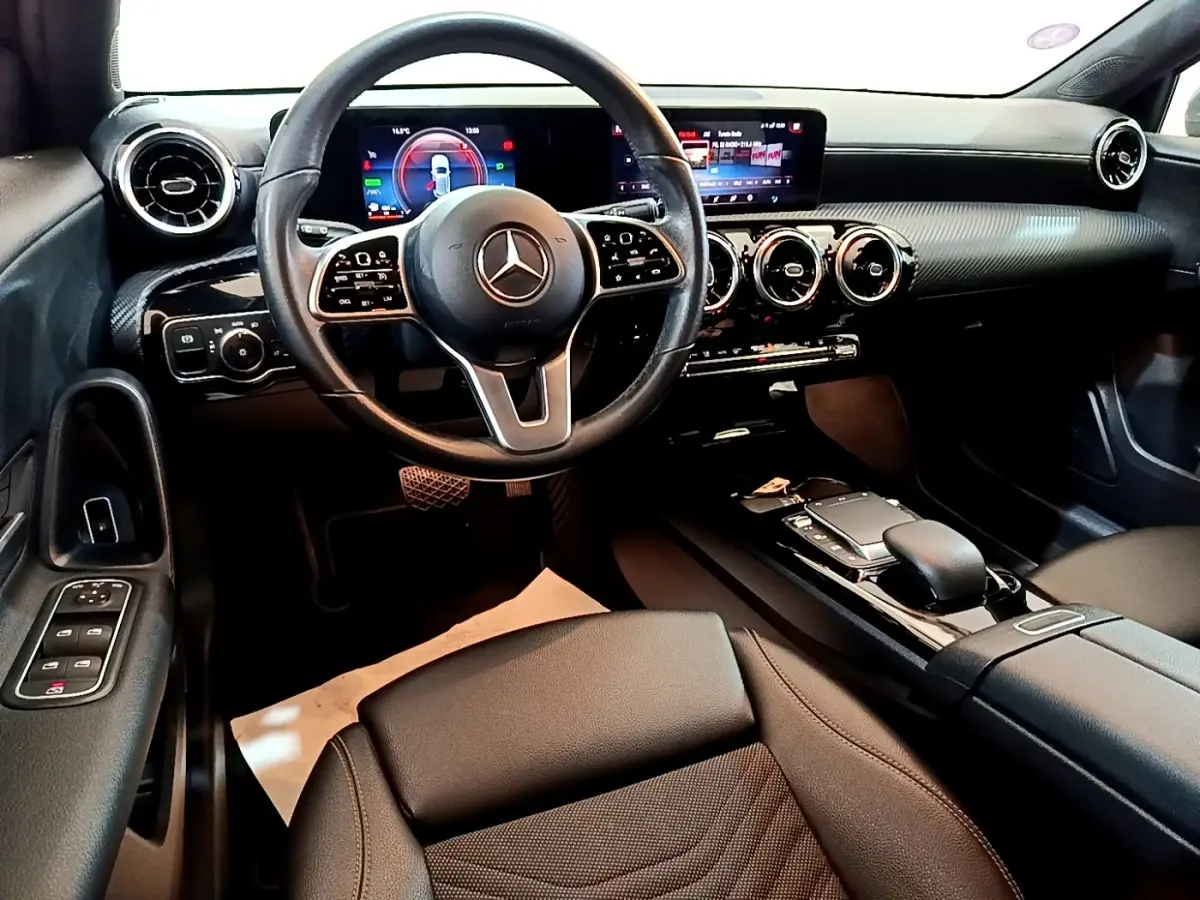 Intérieur noir de la Mercedes Classe A 250 e Business Line 2020, vue depuis le siège conducteur sur le tableau de bord et volant cuir multifonctions.