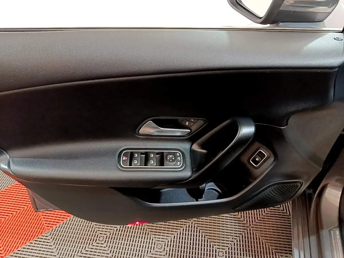 Vue intérieure du panneau de porte côté conducteur noir d'une Mercedes Classe A 250 e Business Line 2020 avec commandes électriques.