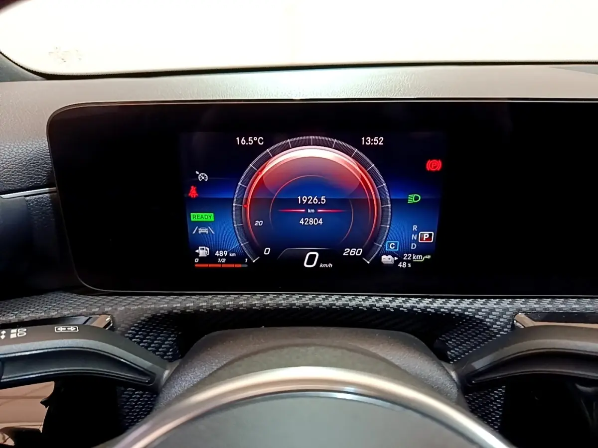 Vue rapprochée du tableau de bord numérique de la Mercedes Classe A 250 e Business Line 2020 avec affichage couleur et éléments de conduite.