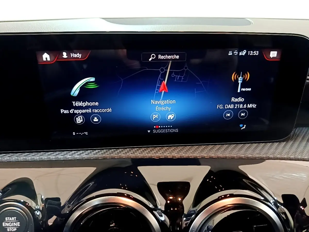 Écran tactile central affichant navigation, téléphone et radio dans le tableau de bord d'une Mercedes Classe A hybride.