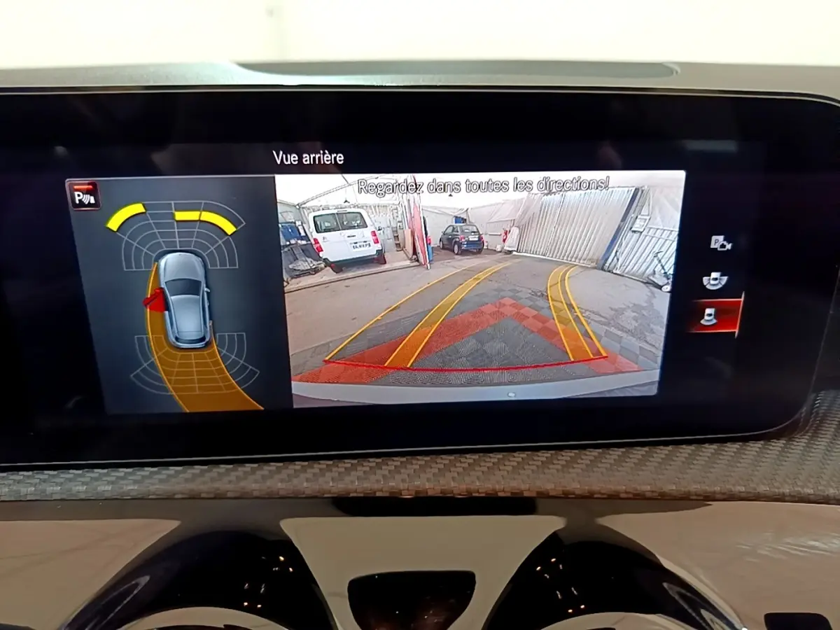 Écran de recul de la Mercedes Classe A 250 e Business Line montrant l’arrière avec lignes de guidage jaunes et rouges.