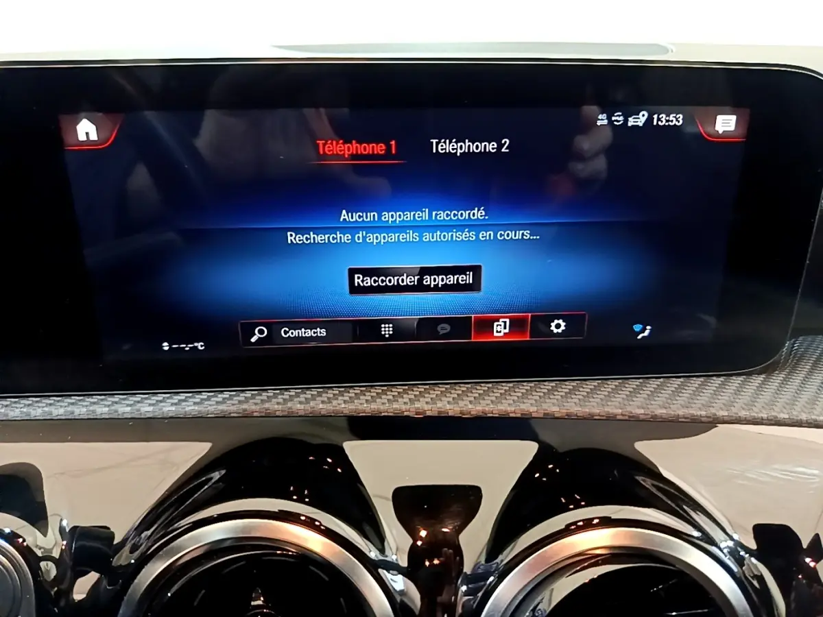 Vue rapprochée de l’écran tactile central et des aérateurs ronds chromés du tableau de bord d’une Mercedes Classe A 250 e.