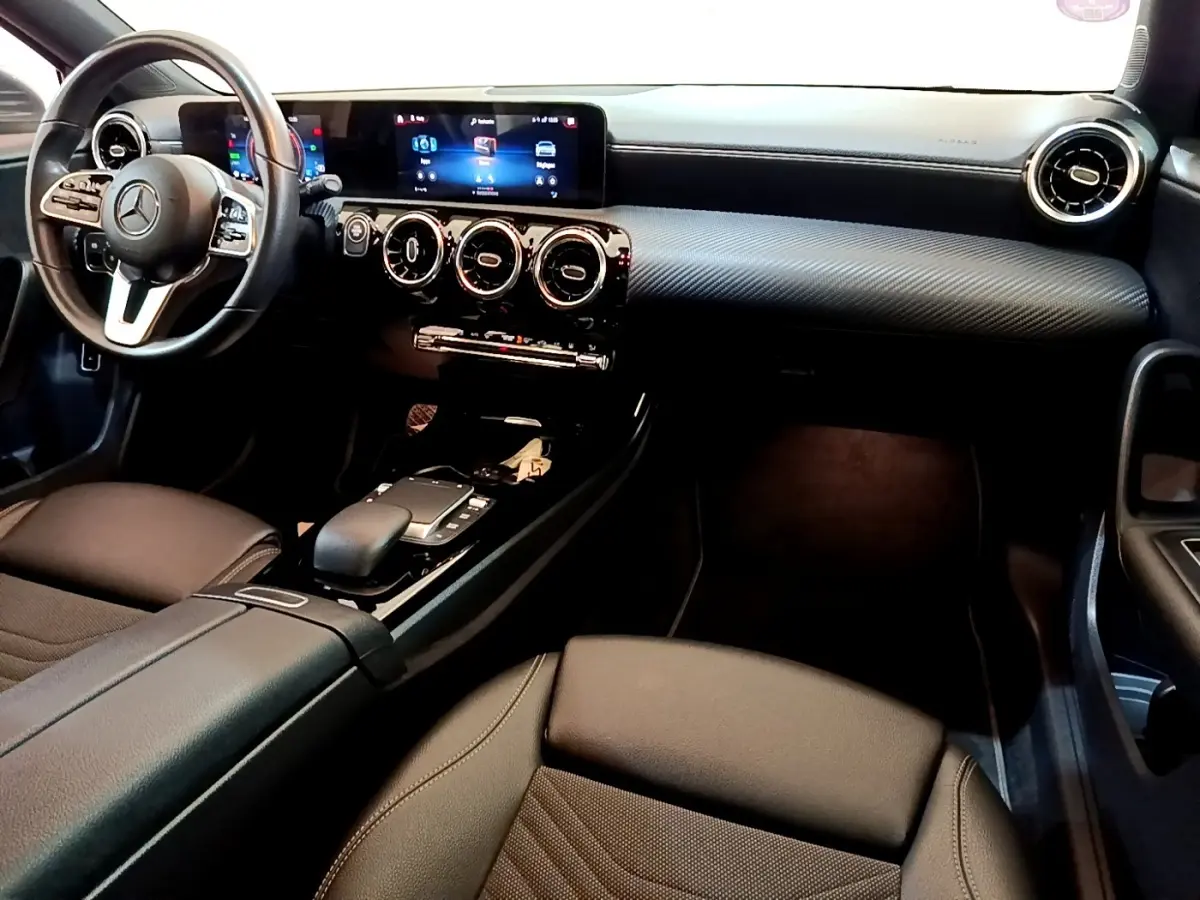 Vue intérieure côté conducteur de la Mercedes Classe A 250 e Business Line 2020, tableau de bord noir et volant cuir multifonctions.