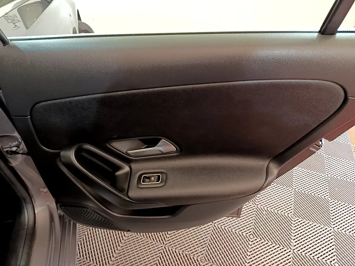 Vue intérieure de la porte côté gauche noire de la Mercedes Classe A 250 e Business Line 2020 avec commande de vitre électrique.