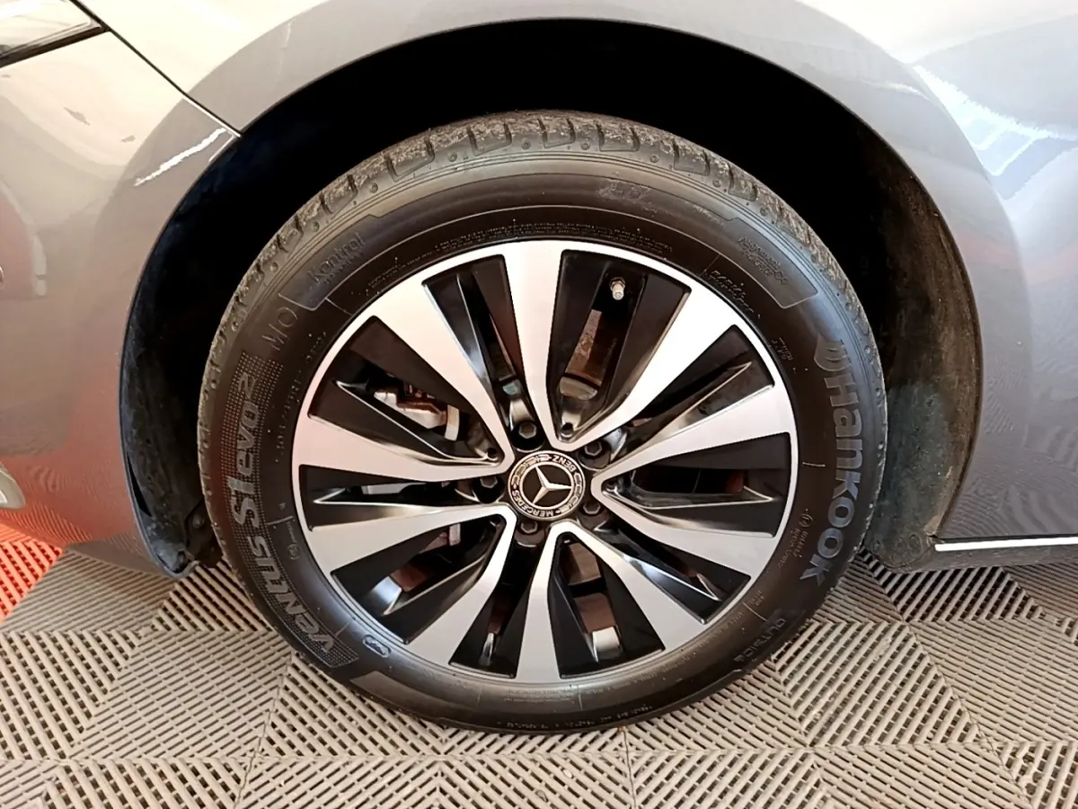 Gros plan sur la roue avant gauche d'une Mercedes Classe A 250 e Business Line gris métallisé avec jante alliage bicolore.