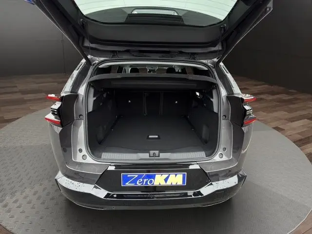 Vue arrière ouverte du coffre du Citroën C5 Aircross gris platinium, mettant en valeur l'espace de chargement vide.