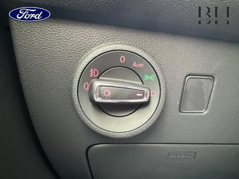 Détail du bouton de commande des phares sur tableau de bord noir d'un SEAT Ateca blanc Nevada Métal.