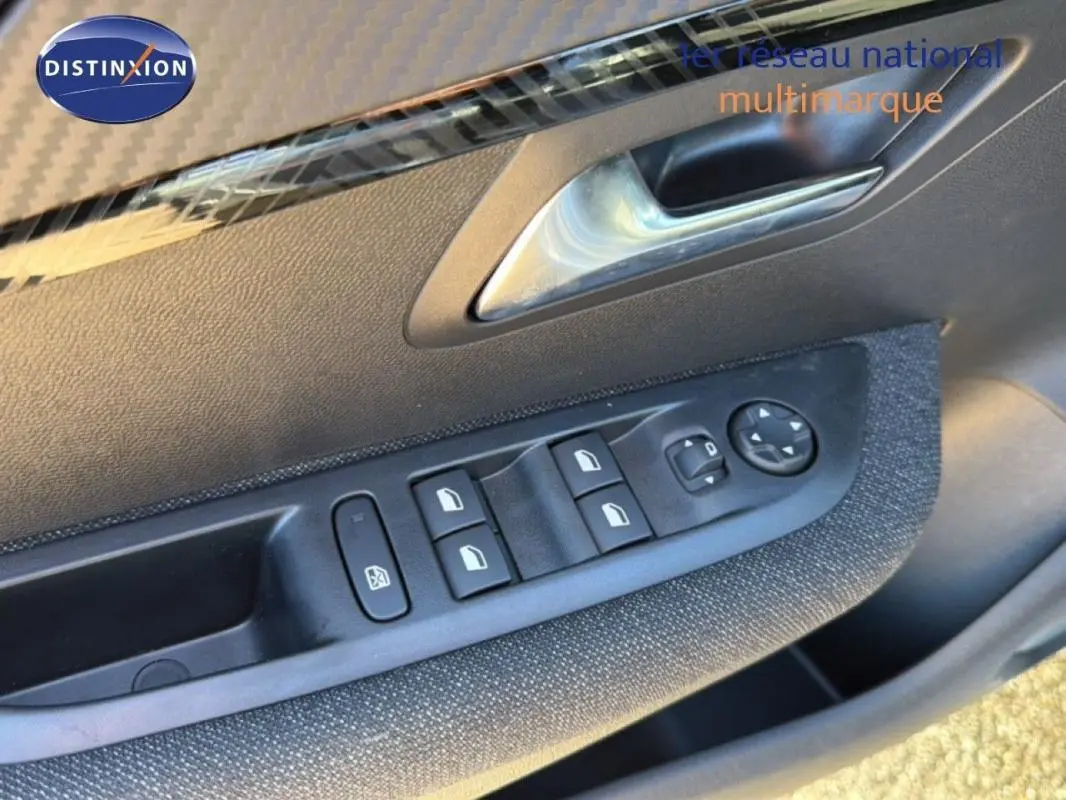 Gros plan sur la commande des vitres électriques et rétroviseurs côté conducteur d'une Peugeot 208 gris 2025.