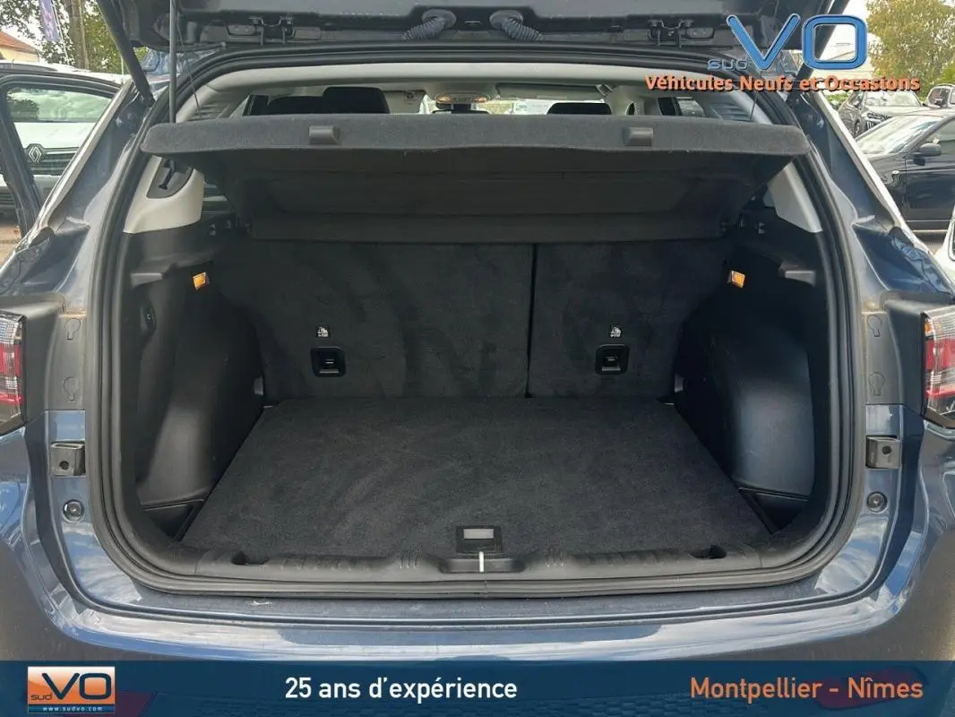 Coffre ouvert vu de l'arrière d'un Jeep Compass bleu 2023, montrant un espace de chargement propre et spacieux.