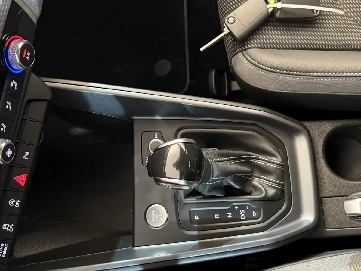 Vue rapprochée de la console centrale de l'Audi A1 gris foncé 2020, avec levier de vitesses automatique et bouton start/stop.