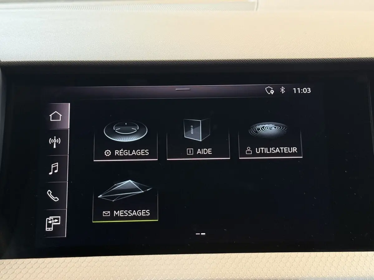 Écran tactile central de l'Audi A1 2020 affichant les options Réglages, Aide, Utilisateur et Messages.