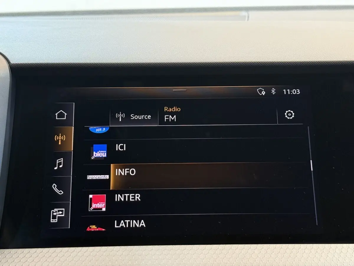 Écran tactile central de l’Audi A1 S line 2020 affichant la sélection des stations radio FM en intérieur noir.