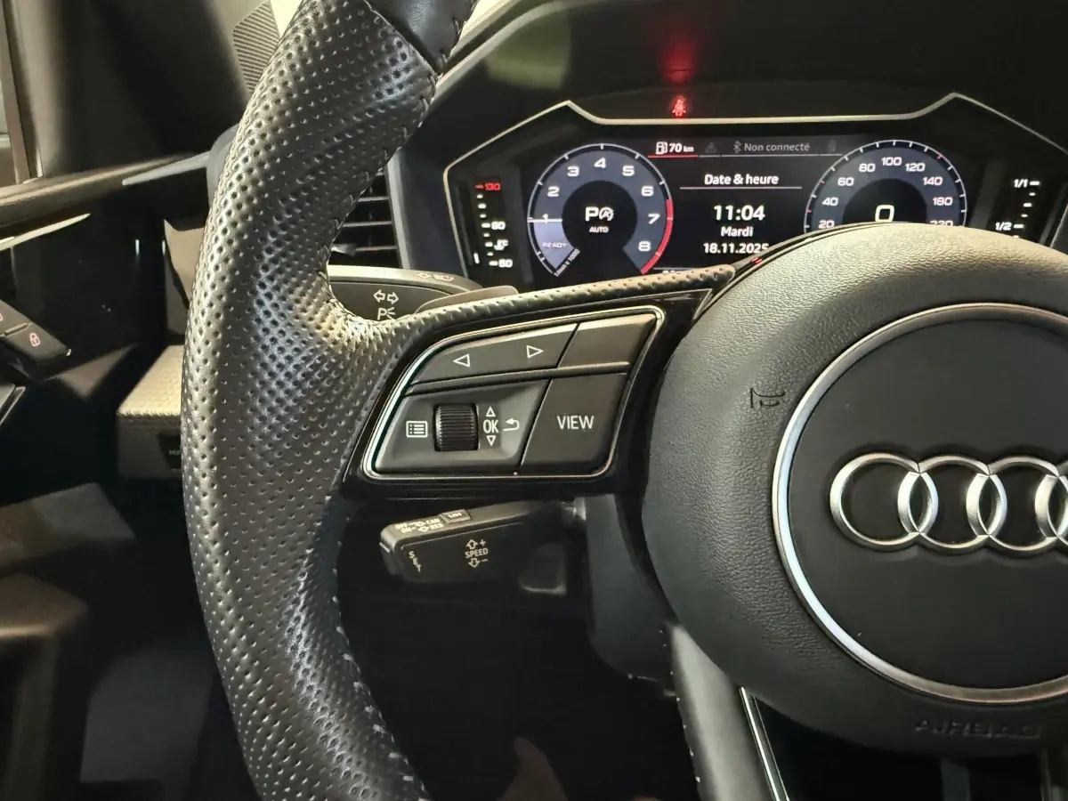 Gros plan sur le volant cuir perforé et le tableau de bord numérique de l'Audi A1 1.5 TFSI S line 2020.