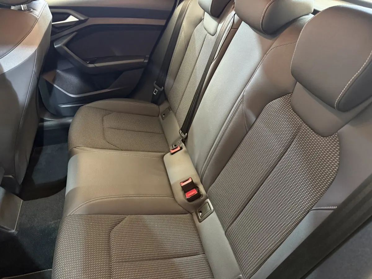 Vue intérieure des sièges arrière gris foncé de l'Audi A1 2020, mettant en valeur la banquette 3 places avec ceintures de sécurité.