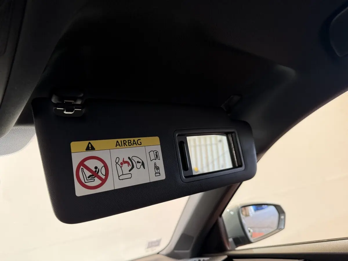Pare-soleil côté conducteur avec miroir et avertissement airbag dans l'Audi A1 gris foncé vue de l'intérieur avant gauche.