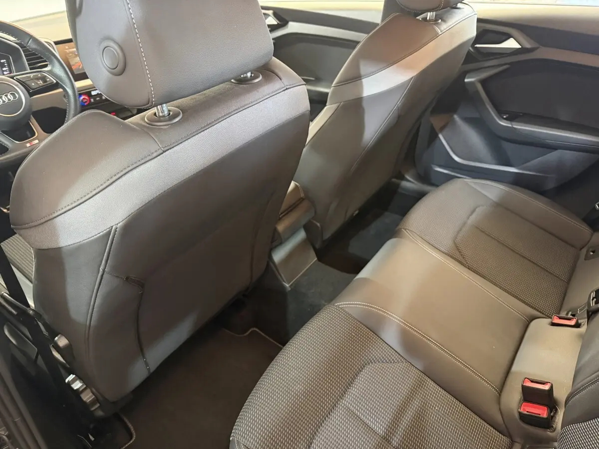 Vue intérieure arrière de l'Audi A1 2020 gris foncé, montrant les sièges en cuir et le tableau de bord partiel.