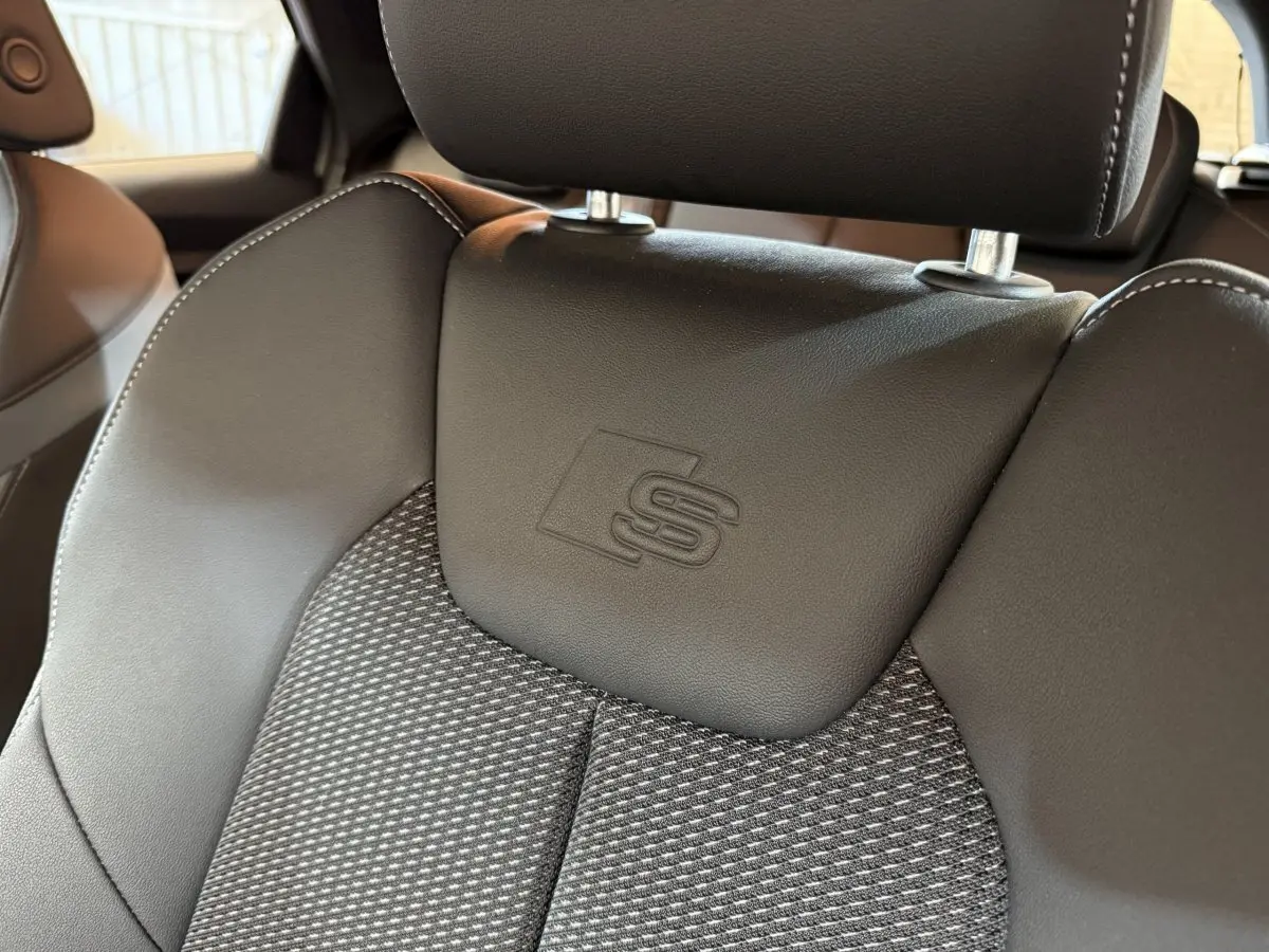 Gros plan sur le siège avant en cuir et tissu gris foncé avec logo S embossé, intérieur Audi A1 S line 2020.