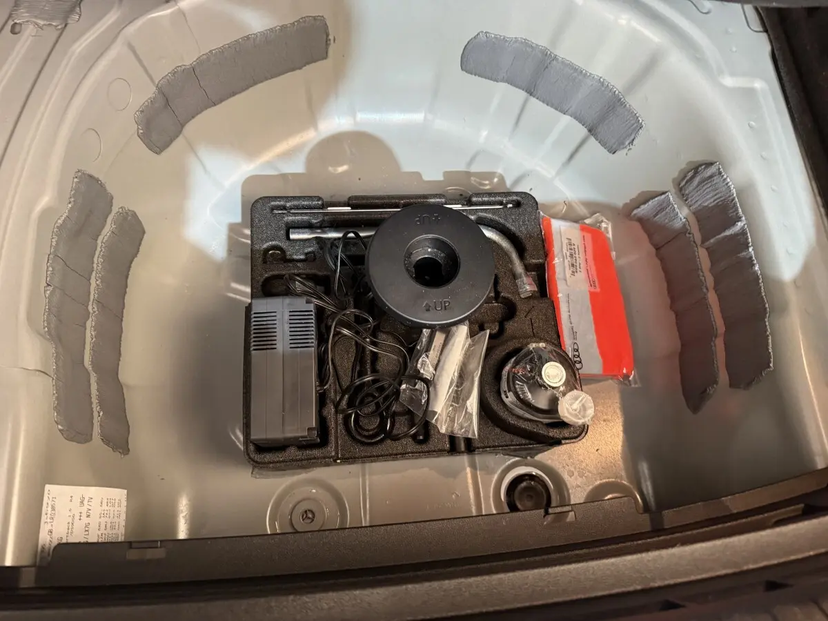 Vue plongeante sur le coffre gris clair de l'Audi A1 2020 montrant le rangement des outils et accessoires d'origine