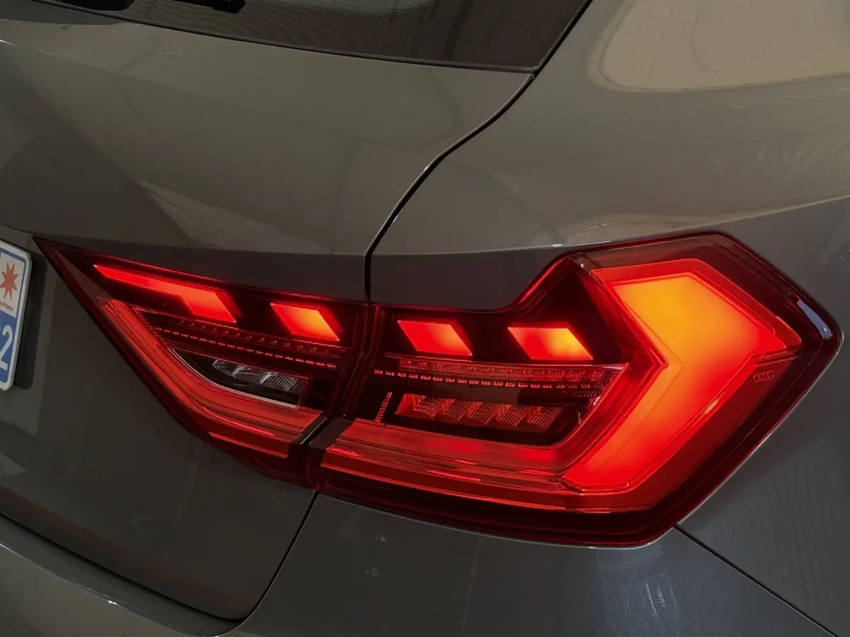 Feu arrière droit allumé d'une Audi A1 gris foncé 2020, mettant en valeur son design LED distinctif.