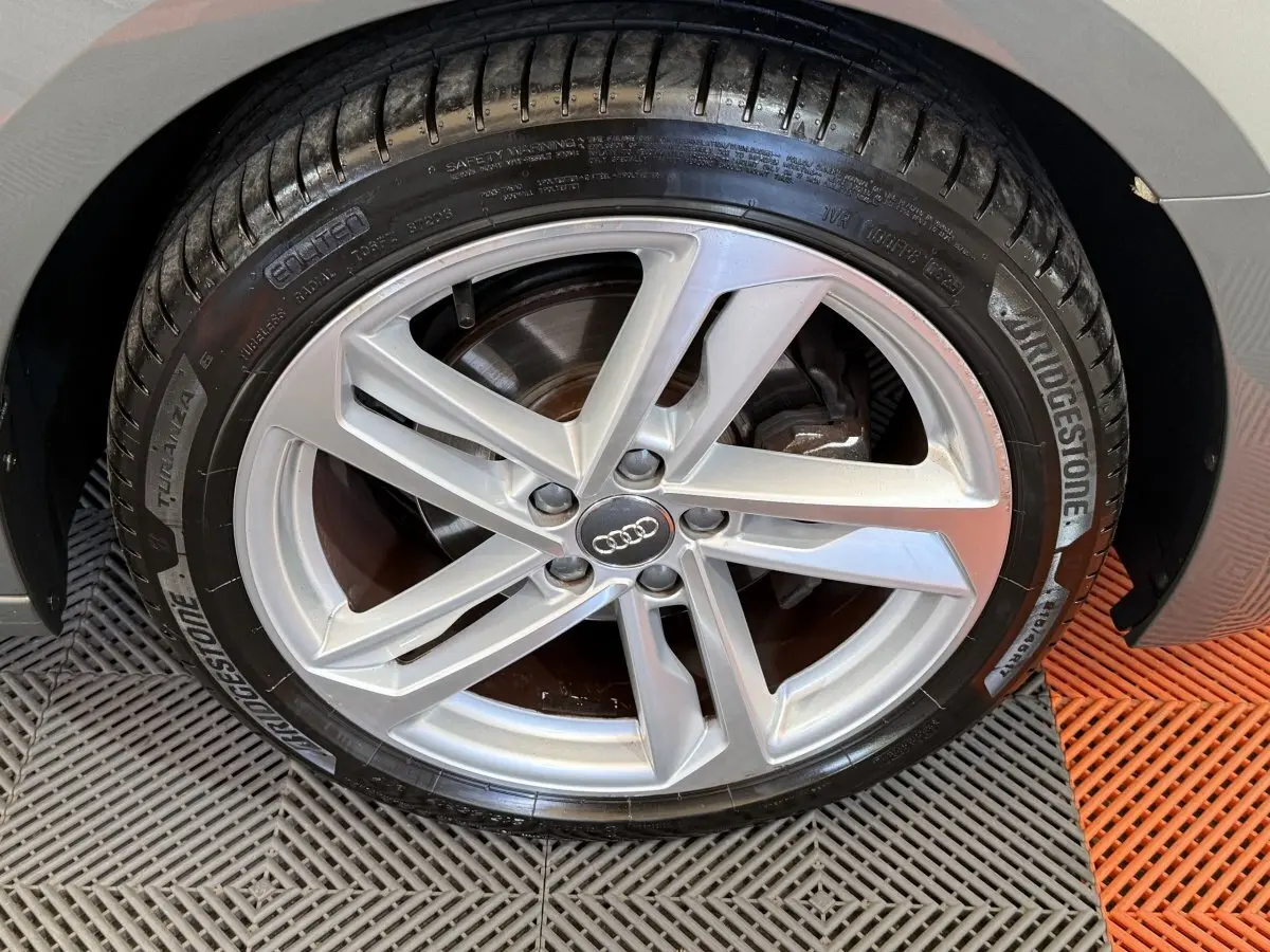 Gros plan sur la jante alliage argentée et pneu Bridgestone du côté arrière droit d'une Audi A1 gris foncé S line 2020.