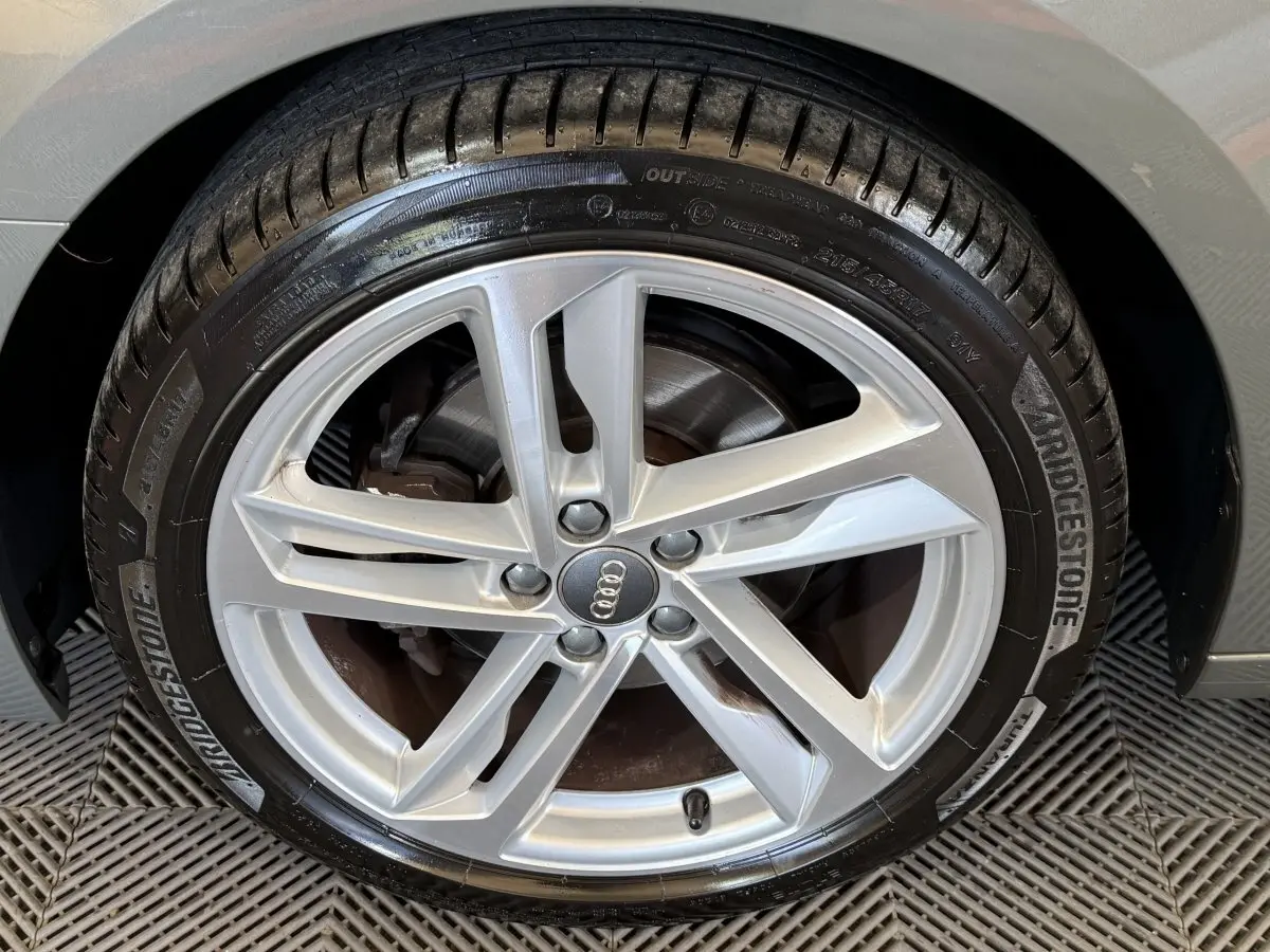 Gros plan sur la jante alliage argentée et pneu Bridgestone du côté gauche d'une Audi A1 gris foncé.