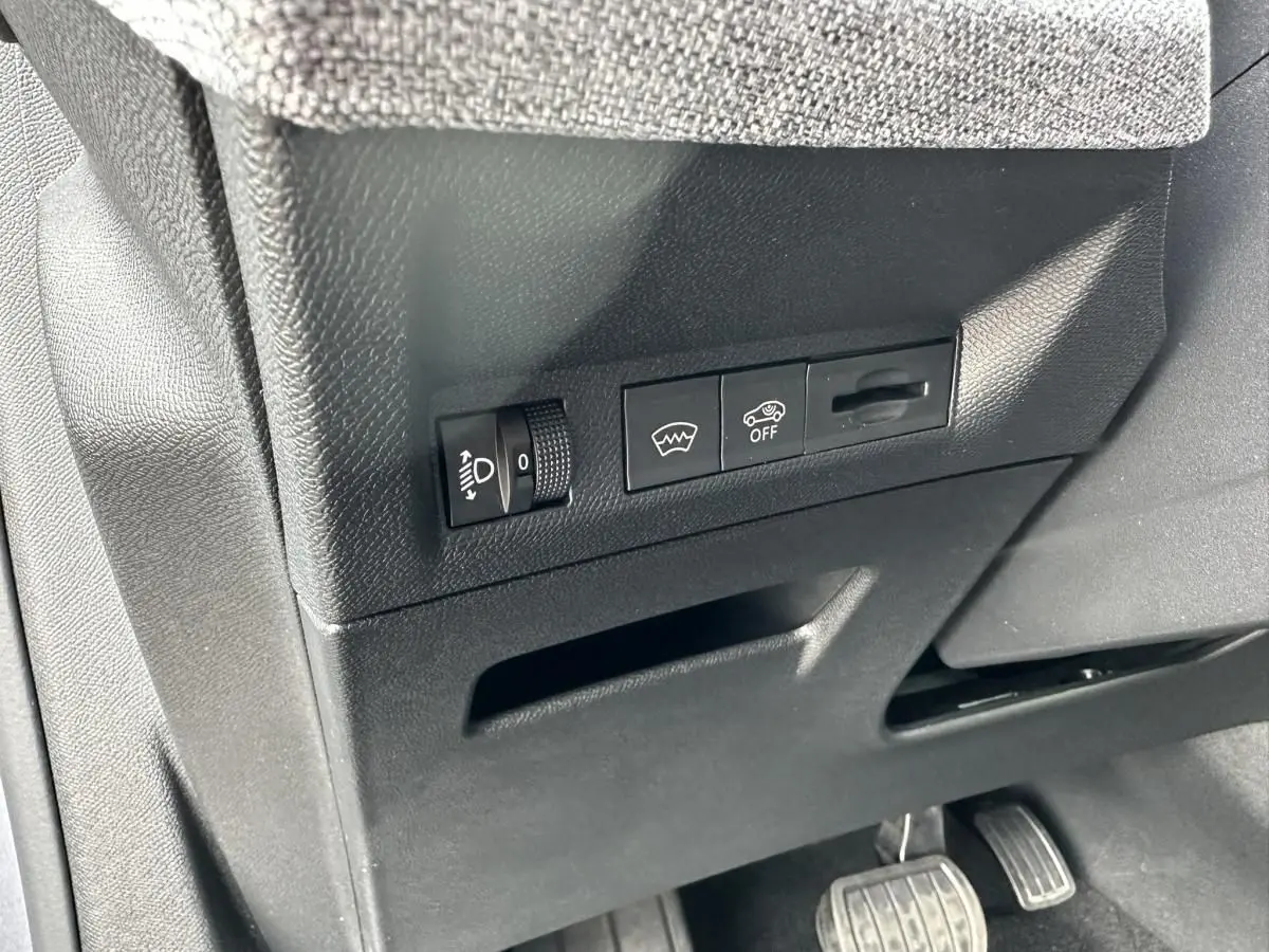 Détail des commandes sous le tableau de bord côté conducteur du Peugeot 3008 gris Artense 2024.