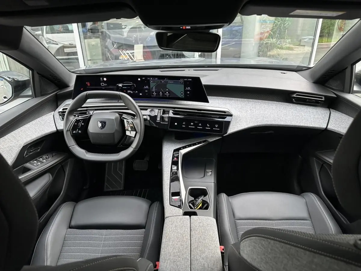 Vue intérieure avant du Peugeot 3008 2024, tableau de bord moderne avec double écran HD et volant compact noir.