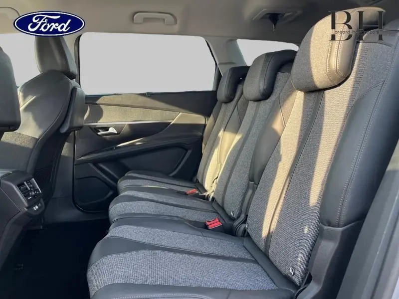 Vue latérale intérieure du Peugeot 5008 2020 gris Artense, montrant les trois sièges individuels en rang 2 avec appuis-tête.